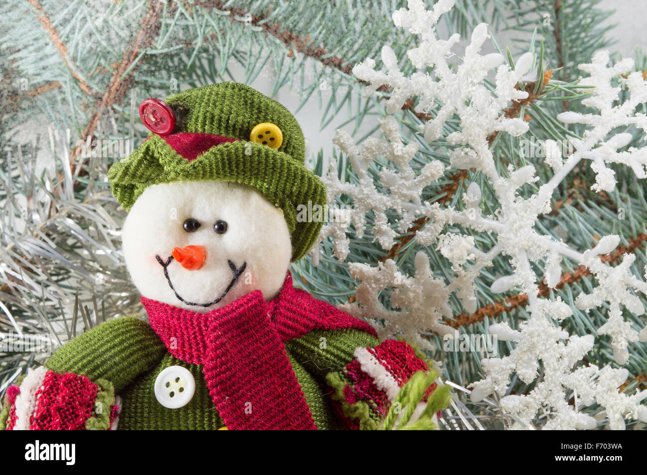 Pupazzo di neve tra i rami di abete con fiocchi di neve. Inverno Foto Stock