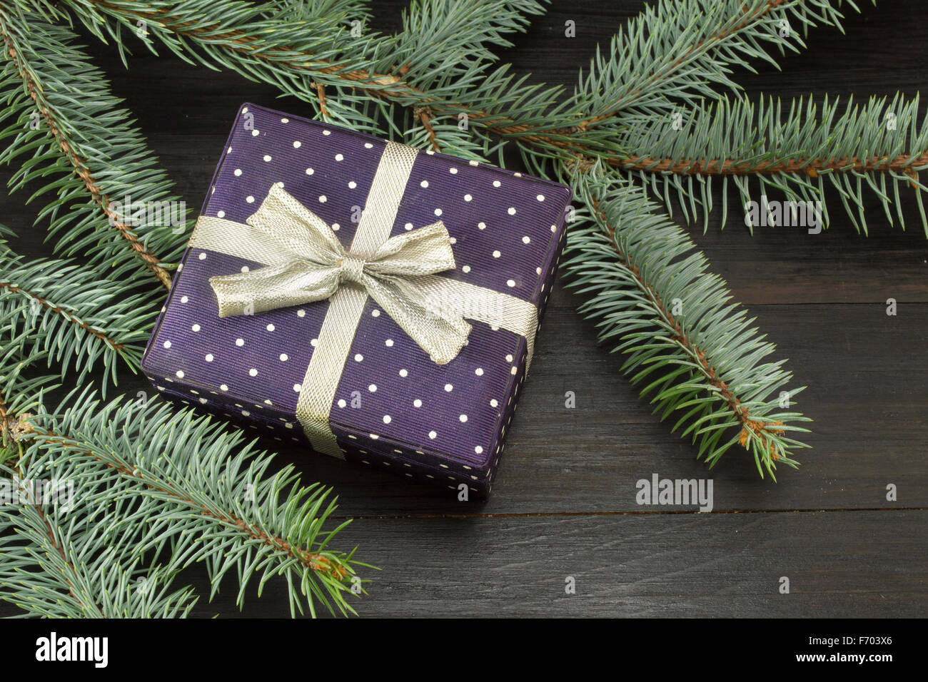 Carino presente casella con un nastro su un abete del ramo. Dare tempo Foto Stock