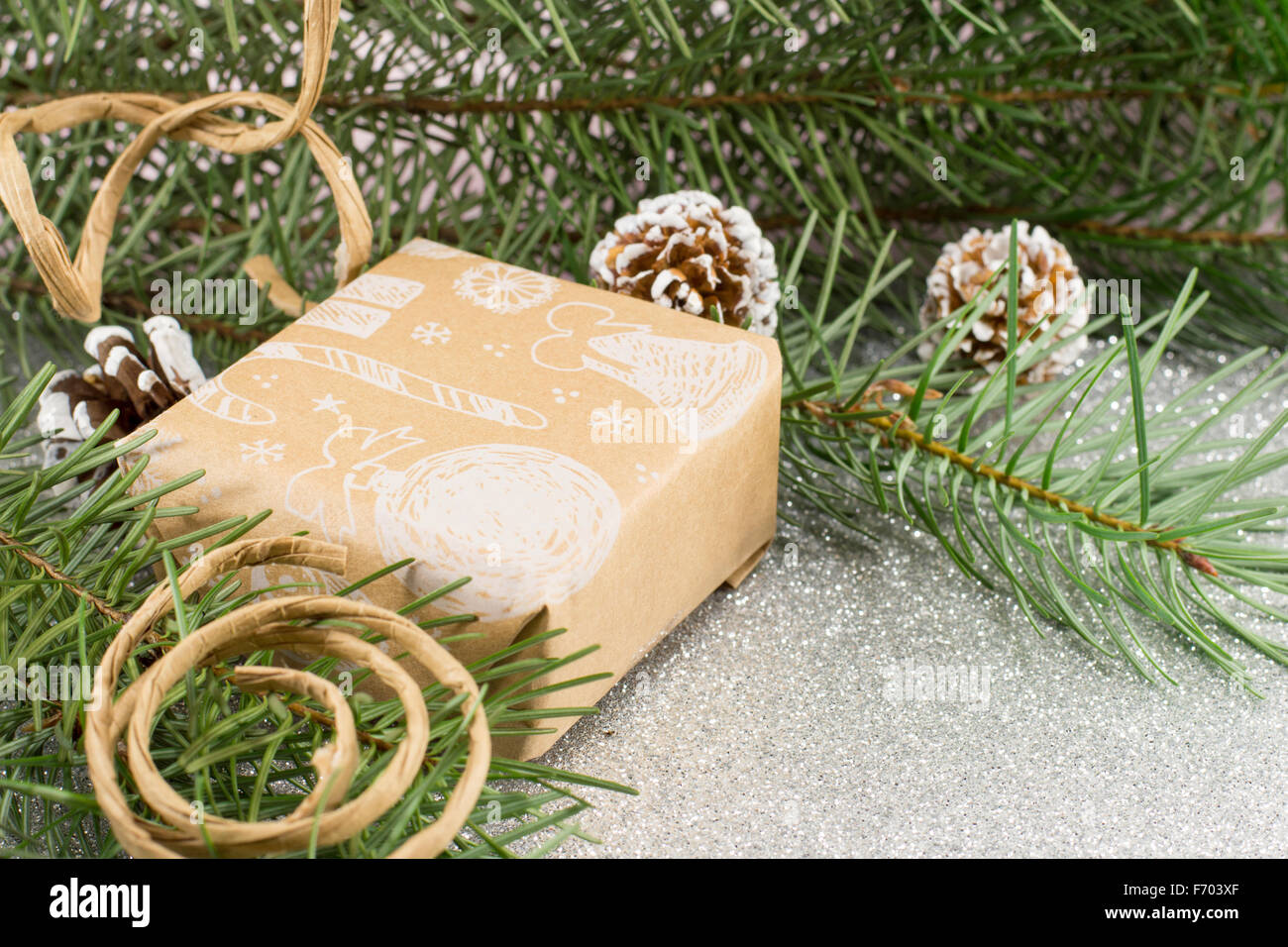 Regalo di natale in una scatola e abete su sfondo lucido Foto Stock