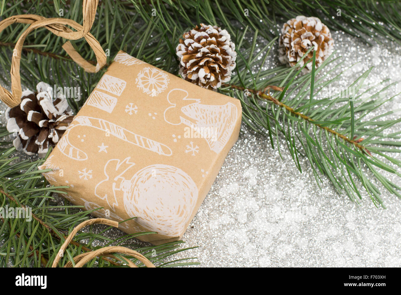 Regalo di natale in una scatola e abete su sfondo lucido Foto Stock