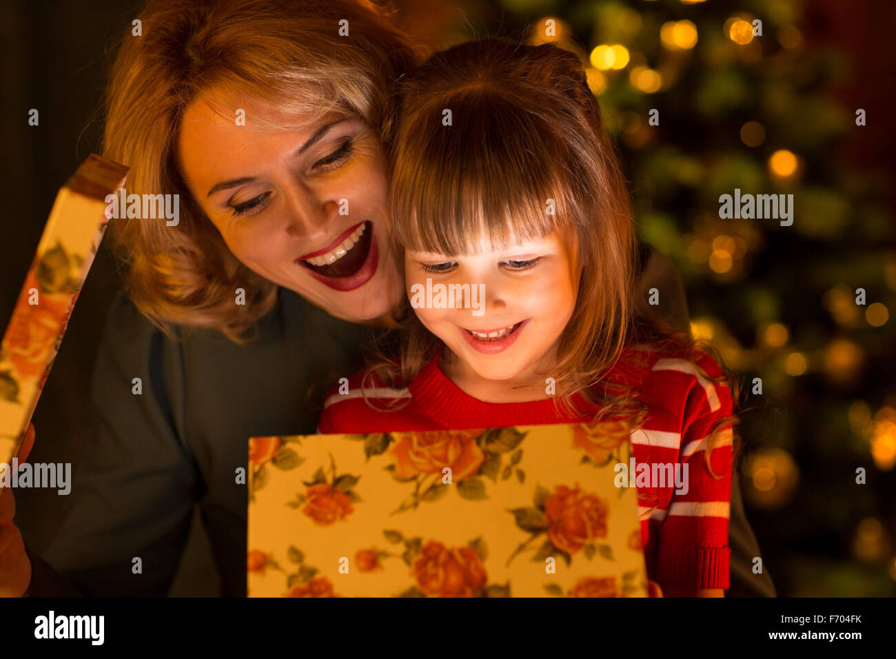 La famiglia felice - madre e figlia bambino aprire il natale confezione regalo Foto Stock
