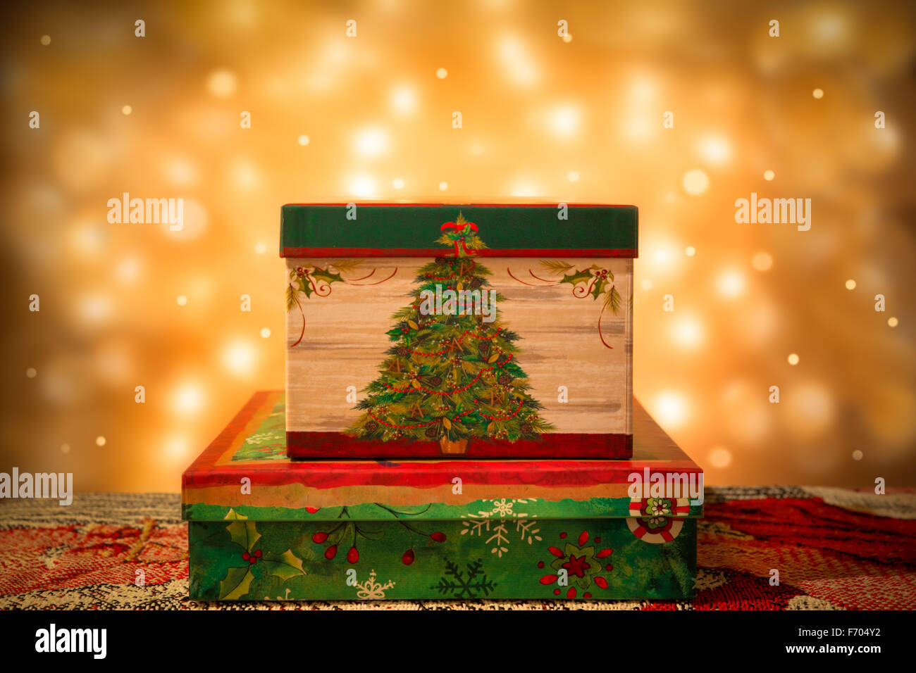 Decorative per le vacanze di Natale confezioni regalo con luci d'oro in background Foto Stock