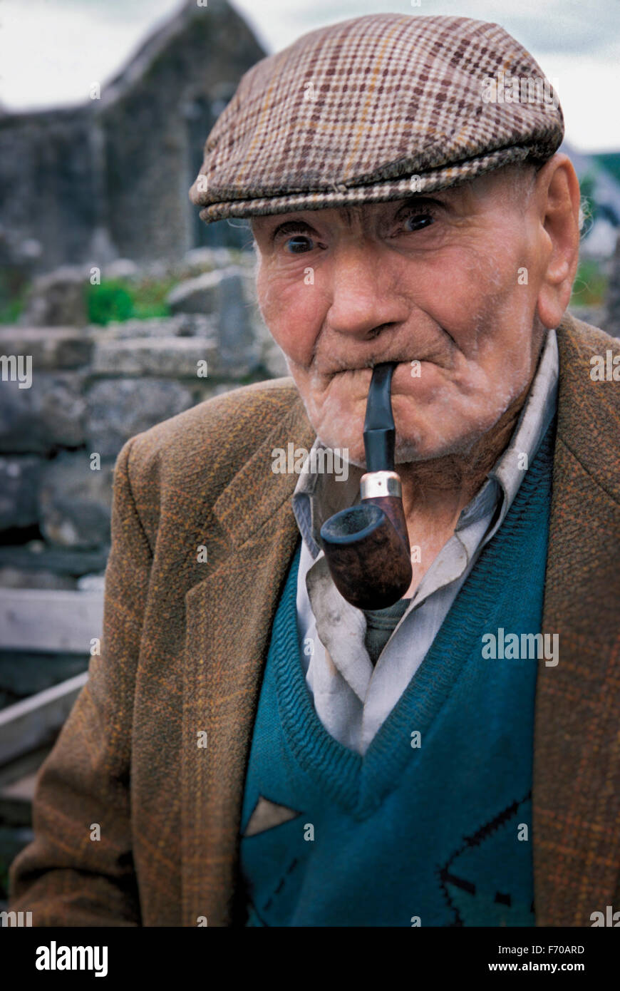 Un uomo irlandese fuma la sua pipa. Burren, Irlanda. Foto Stock