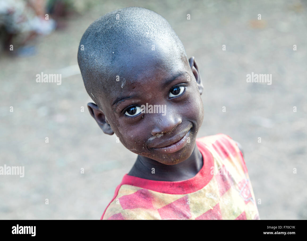 Ritratto su un bambino africano di etnia fula sorridente alla fotocamera, la revisione di vita quotidiana della gente locale nelle zone rurali DI GUINEA-BISSAU Foto Stock