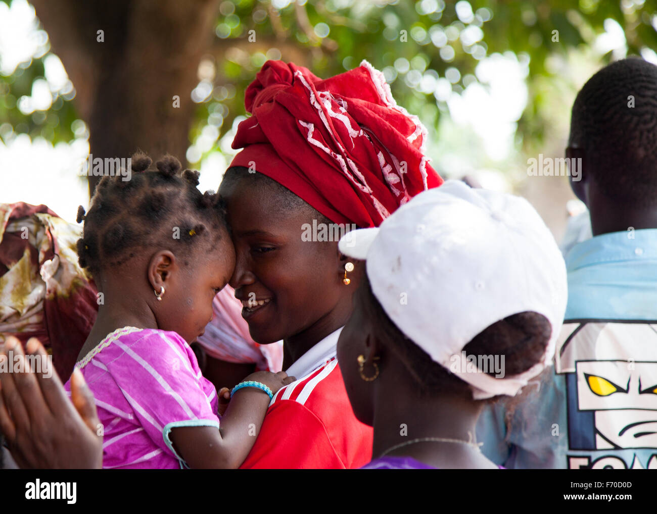 Gabu, Guinea Bissau - 15 Maggio 2014: Ritratto di un non ben identificato bella ragazza africana mentre tiene il suo bambino Foto Stock