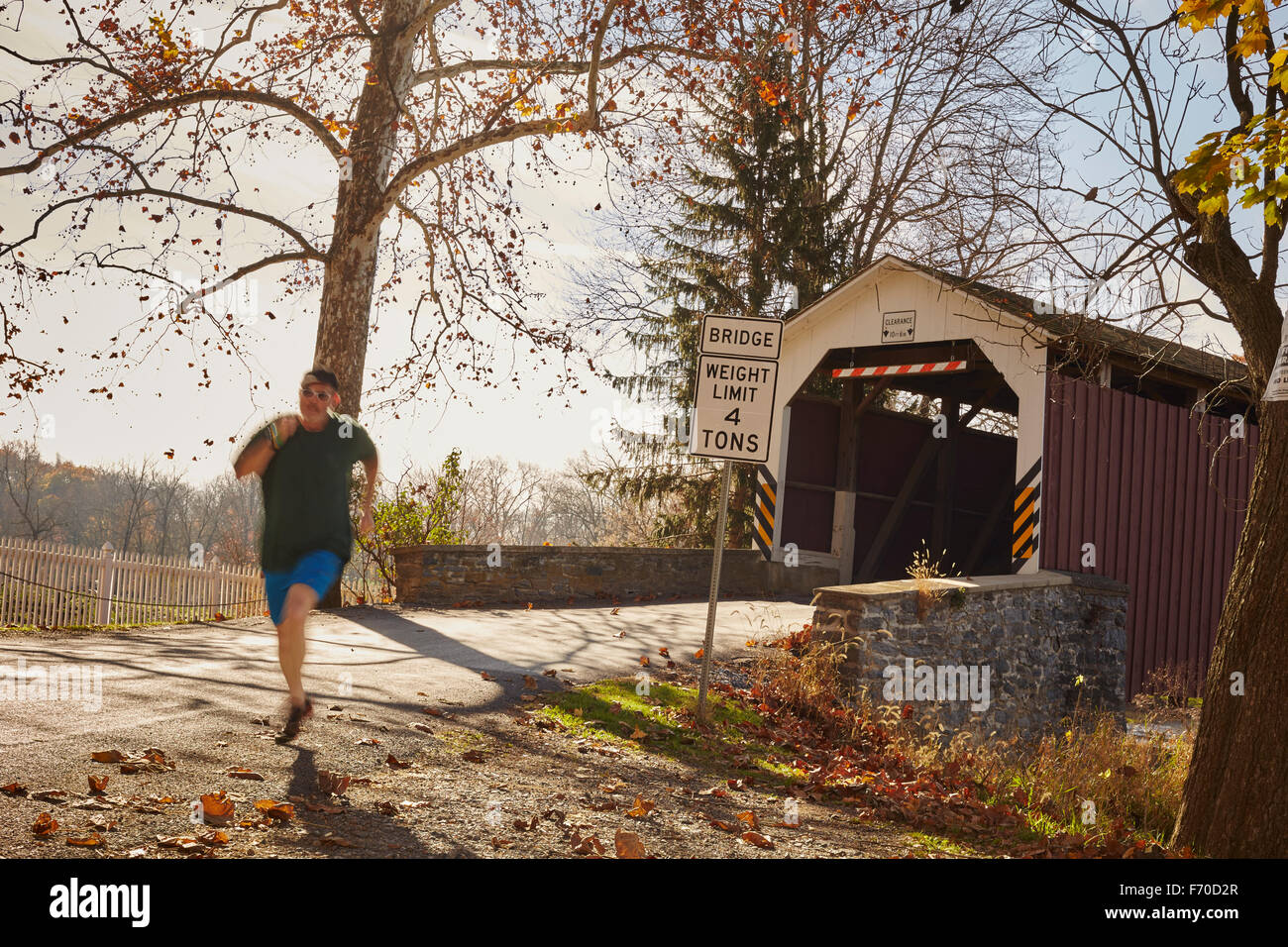 Uomo che corre lungo una strada di campagna, a Lancaster, Pennsylvania, STATI UNITI D'AMERICA Foto Stock