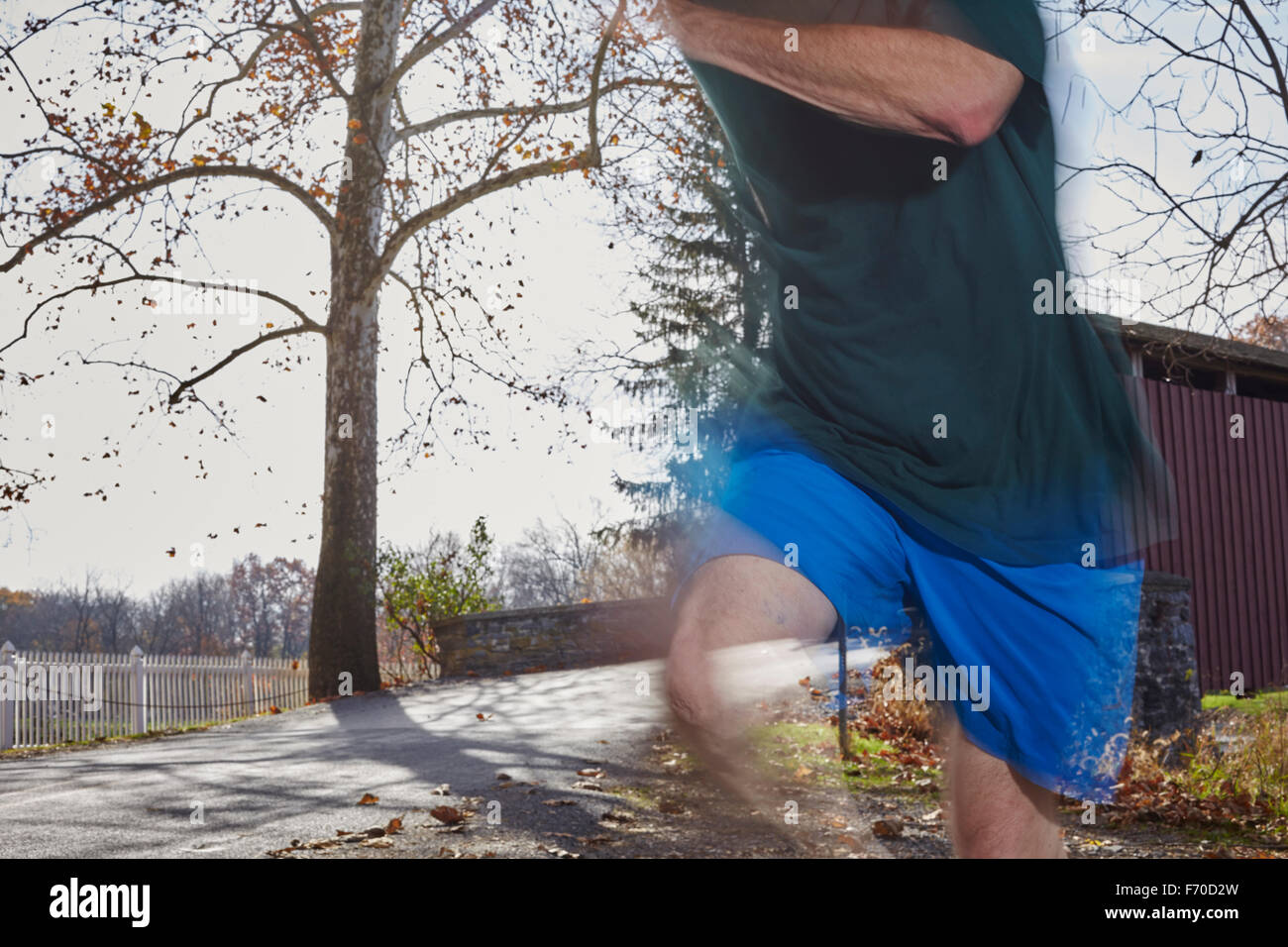 Uomo che corre lungo una strada di campagna, a Lancaster, Pennsylvania, STATI UNITI D'AMERICA Foto Stock