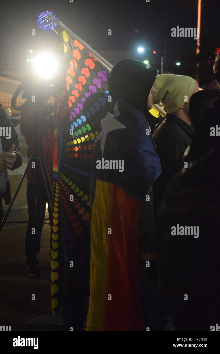 Dallas, Texas, Stati Uniti d'America. 22 Novembre, 2015. LGBT protester drappeggiati in un Gay Pride colorato bandiera Texas come un equipaggio news film la protesta di fronte Dallas questura domenica notte. Credito: Brian T. Humek/Alamy Live News Foto Stock