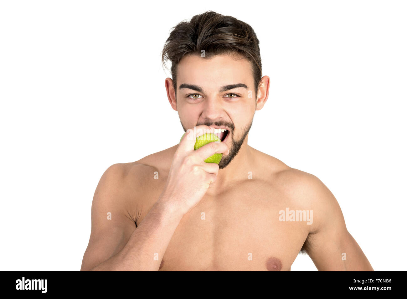 Bello e montare il giovane uomo mangiare un apple isolato in bianco Foto Stock