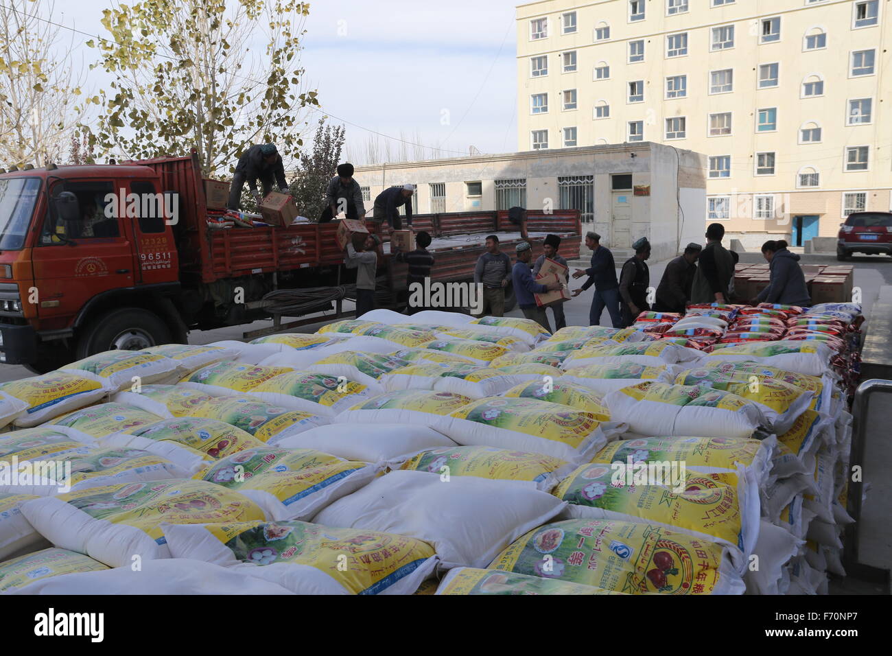 Pishan cinese Xinjiang Uygur Regione autonoma. Xxi Nov, 2015. La gente ottenere riso e farina in Pixina township di Pishan County, a nord-ovest della Cina di Xinjiang Uygur Regione autonoma, nov. 21, 2015. Pixina Township era l area più colpita da un terremoto nel mese di luglio. Il 6,5-grandezza quake tremò Pishan County, abitata prevalentemente da persone di etnia Uygur, il 3 luglio e a sinistra tre morti e 263 altri feriti. © Xu Xiaolong/Xinhua/Alamy Live News Foto Stock