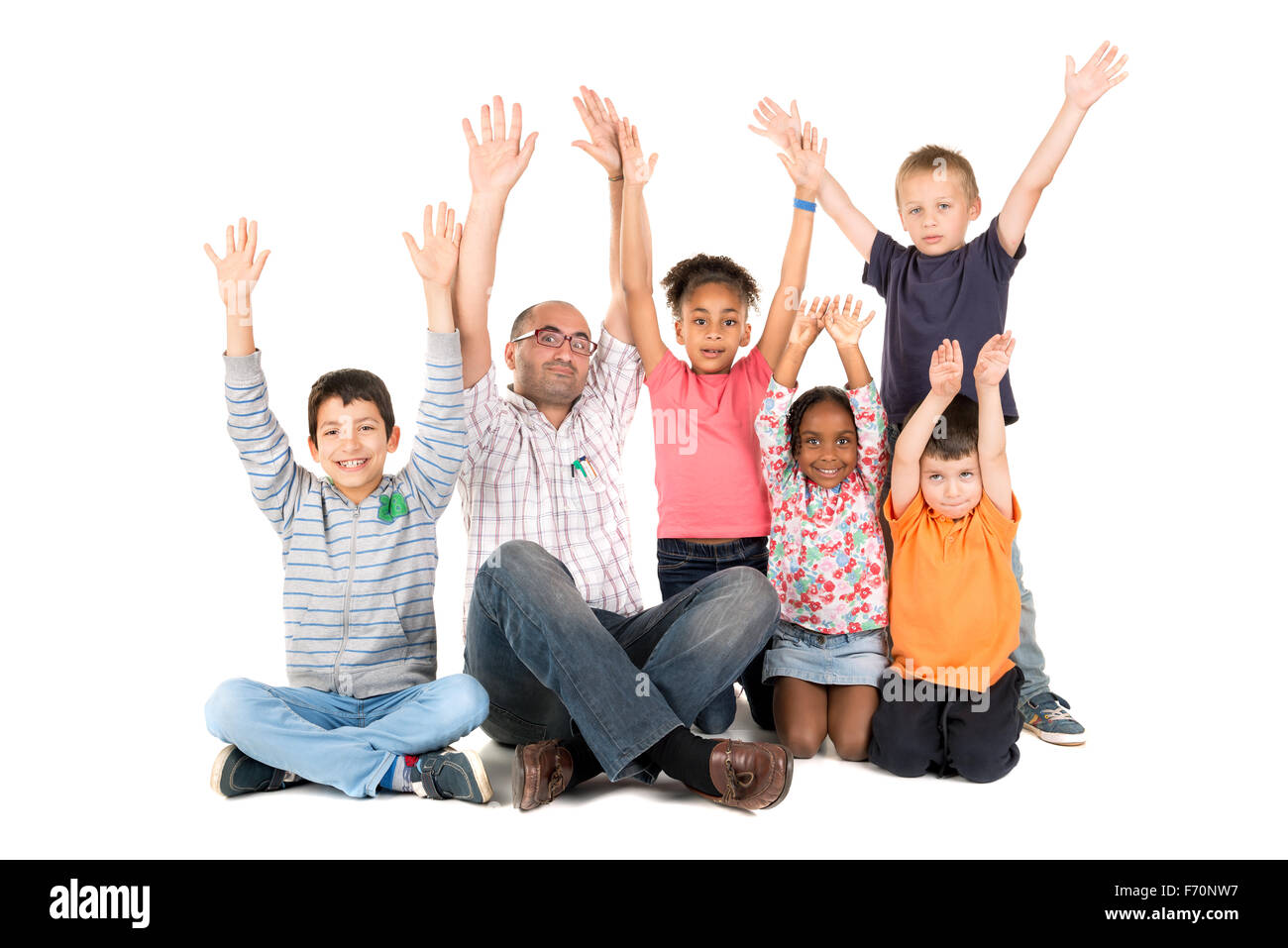 Gruppo di bambini con insegnante alzando le loro mani isolato in bianco Foto Stock
