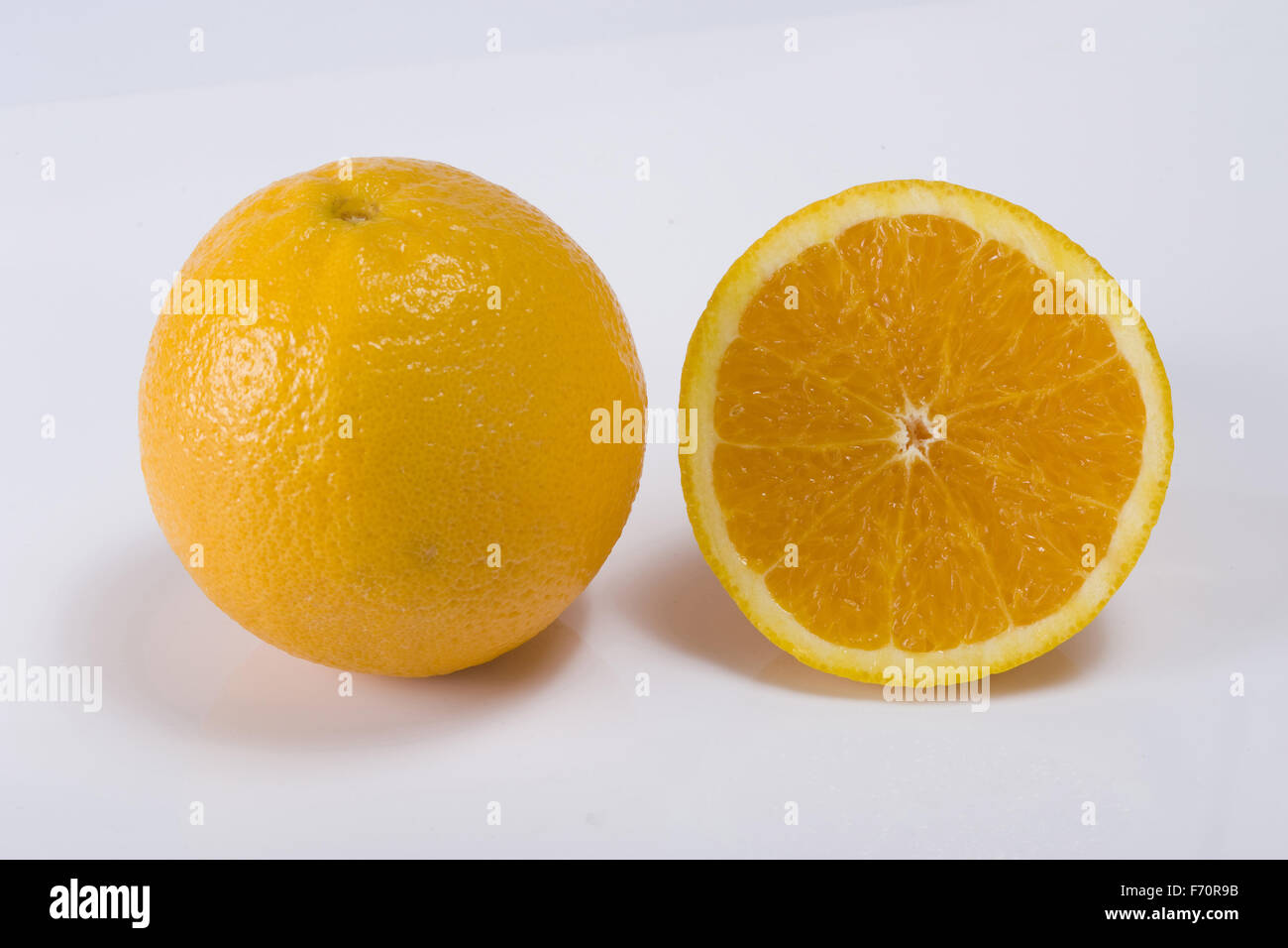 Frutta arancione un intero un taglio su sfondo bianco Foto Stock