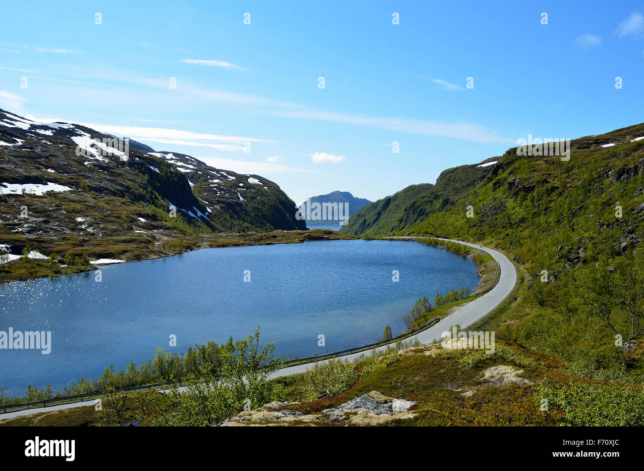 Lago di montagna in estate con il trasporto su strada sul lato Foto Stock