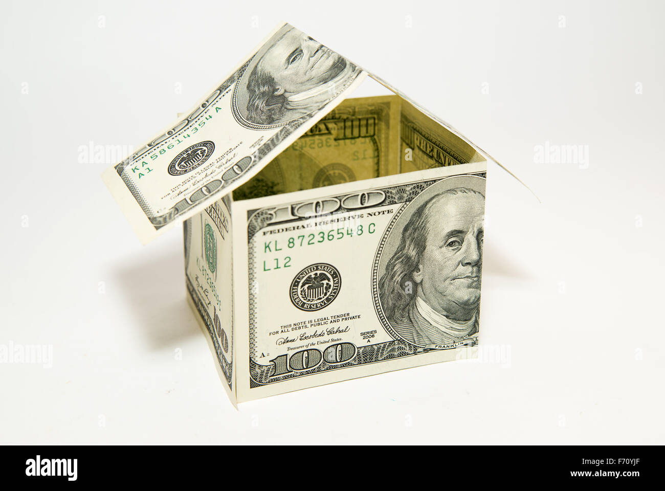US dollar banconote sul display nella forma di una casa su bianco Foto Stock