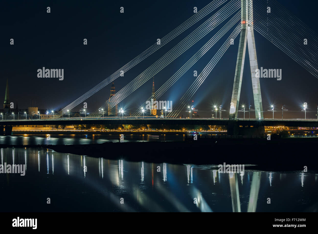 Cavo alloggiato a ponte e fiume Daugava di notte, Riga, Lettonia Foto Stock