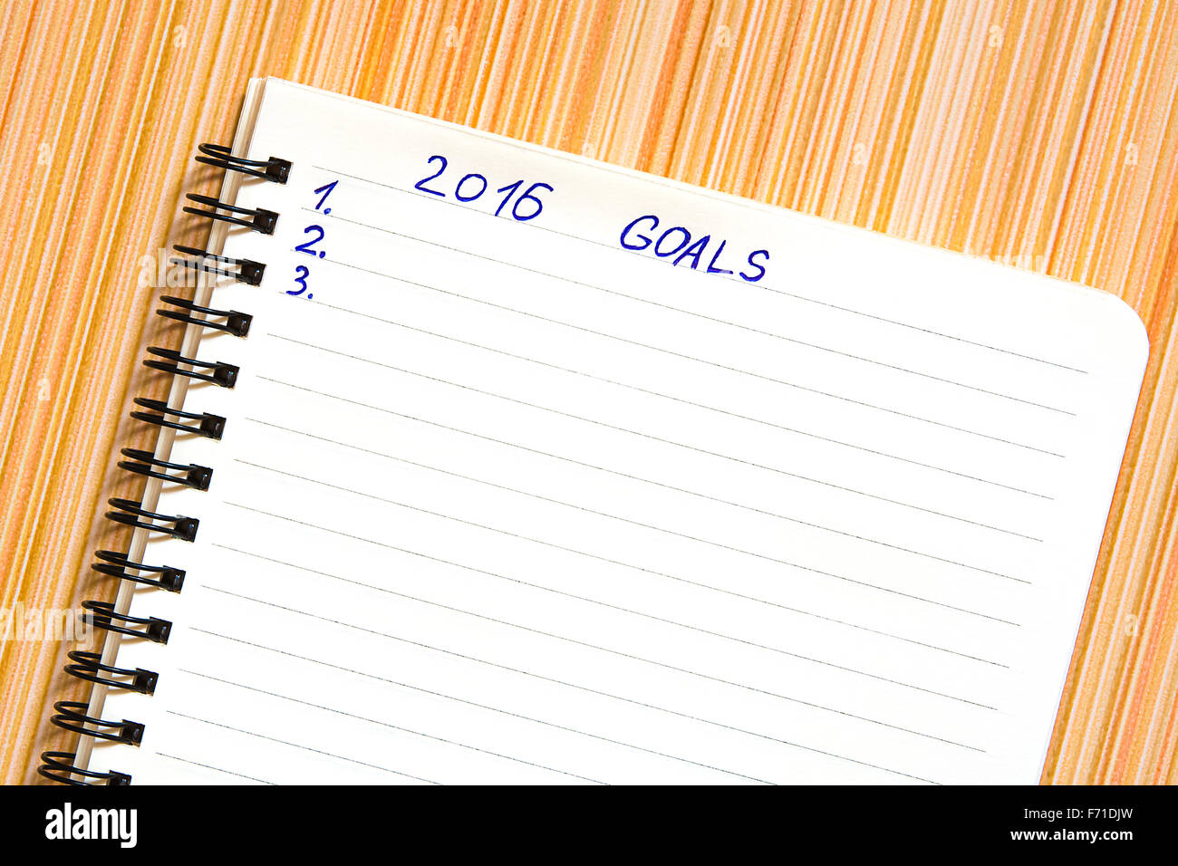 Notebook con gli obiettivi dell'anno 2016 su striped sfondo arancione Foto Stock