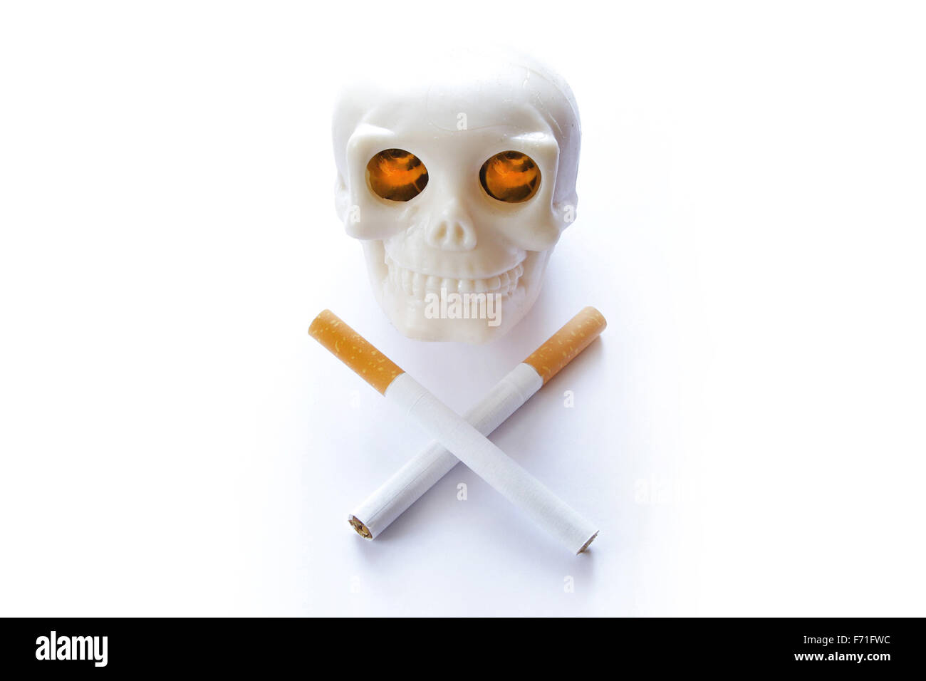 Il fumo uccide vintage teschio umano con ardente illumina gli occhi e sigarette invece cross ossa su sfondo bianco Foto Stock