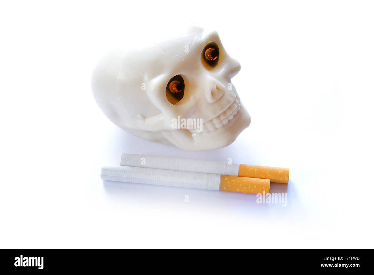 Il fumo uccide vintage teschio umano con ardente illumina gli occhi e sigarette su sfondo bianco Foto Stock