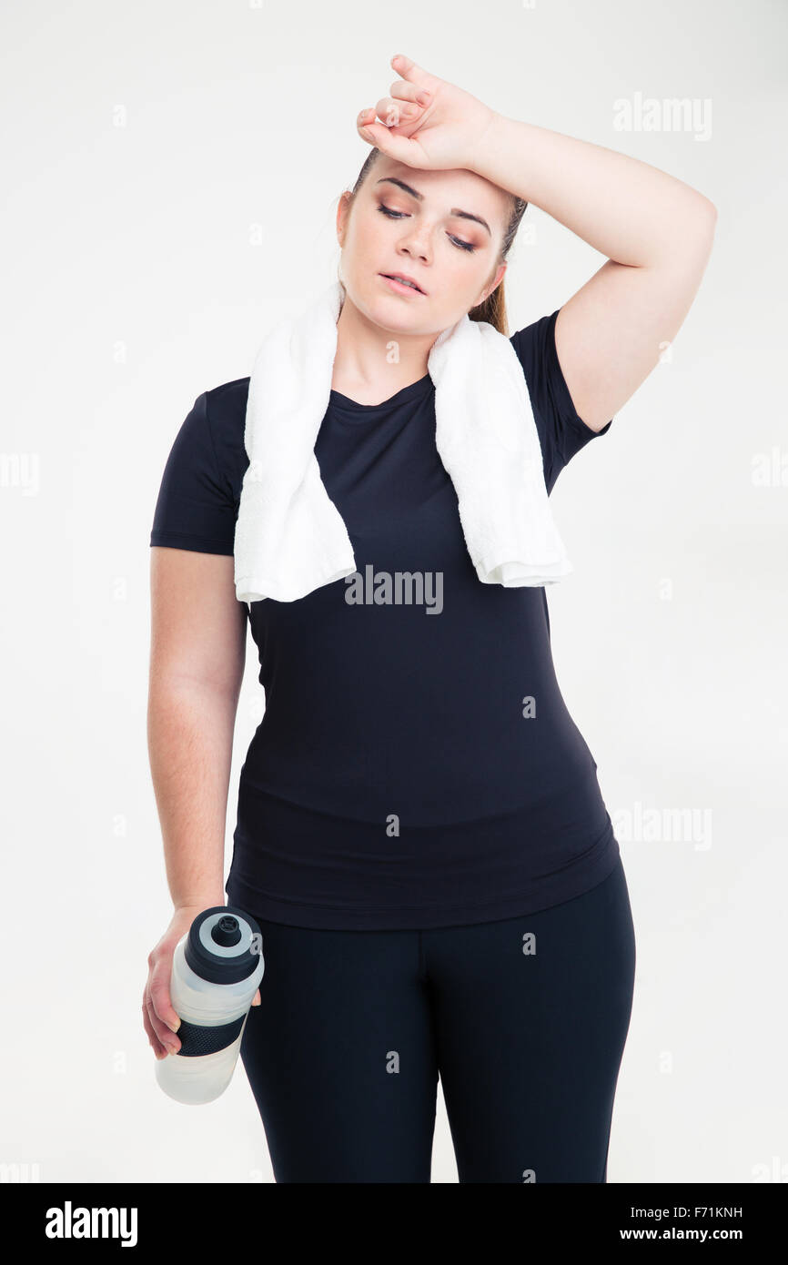 Ritratto di una stanca donna grassa in sports wear in piedi isolato su uno sfondo bianco Foto Stock
