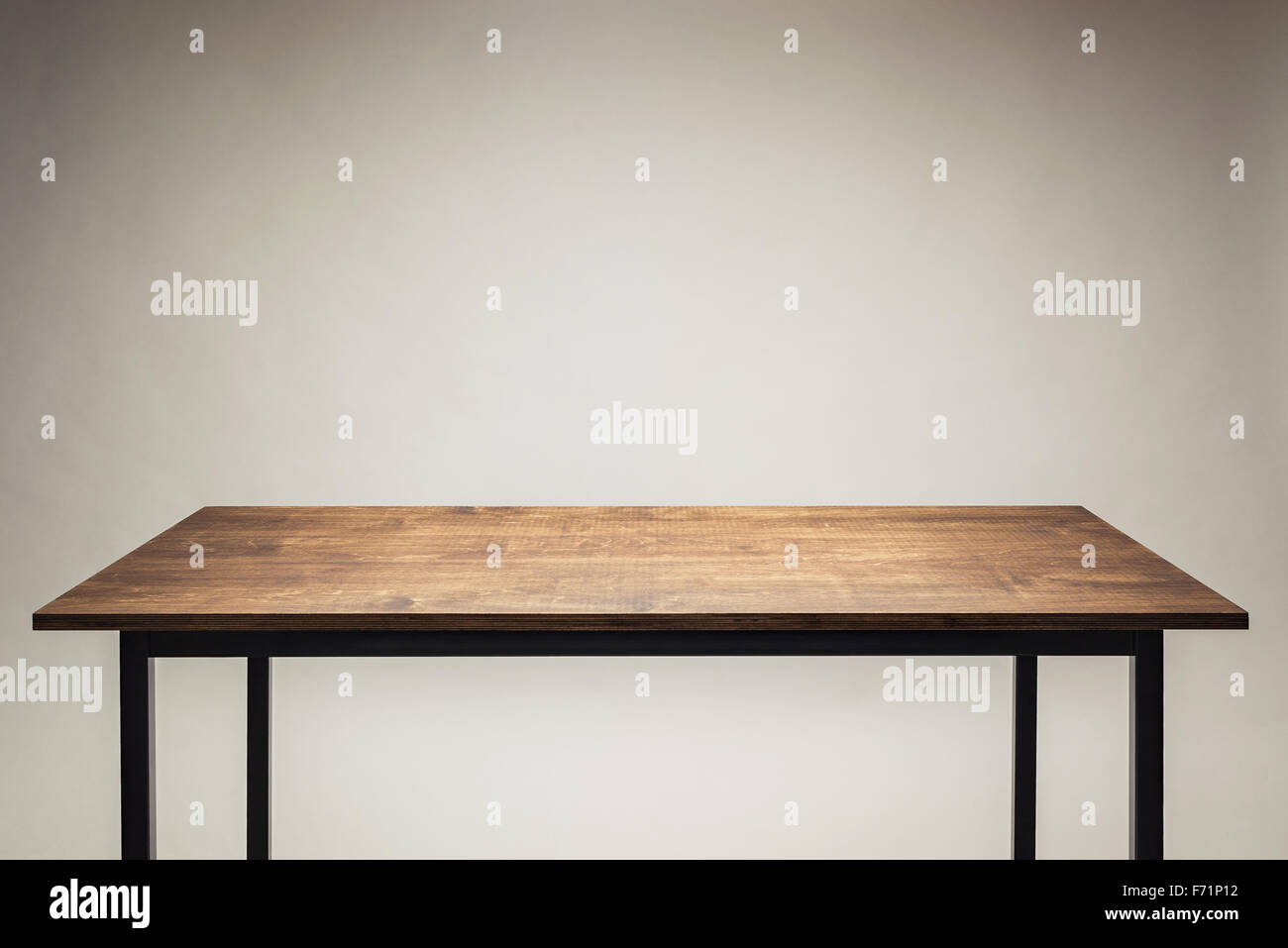 Tavolo in legno contro uno sfondo grigio. Foto Stock