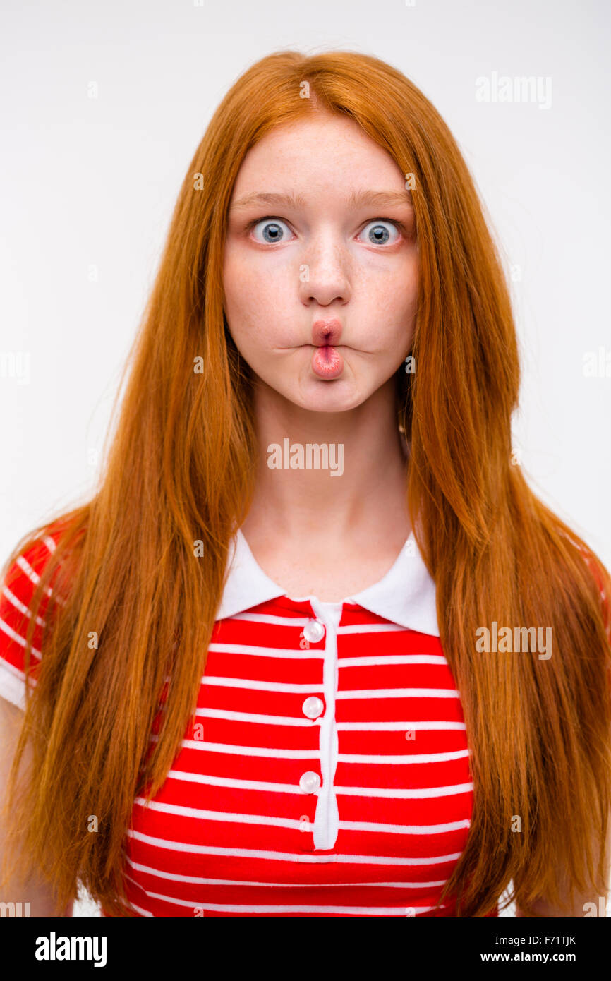 Funny divertente redhead girl ingannare geografica e facendo facce buffe su sfondo bianco Foto Stock