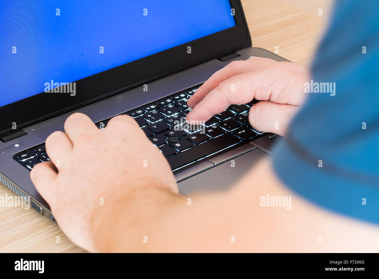Uomo scrive su una tastiera portatile Foto Stock