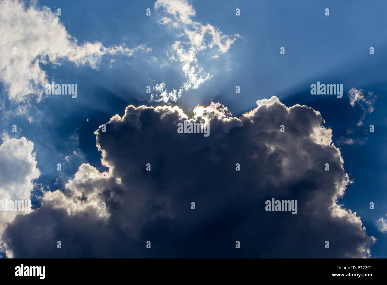 Sun peeping intorno le nuvole Foto Stock
