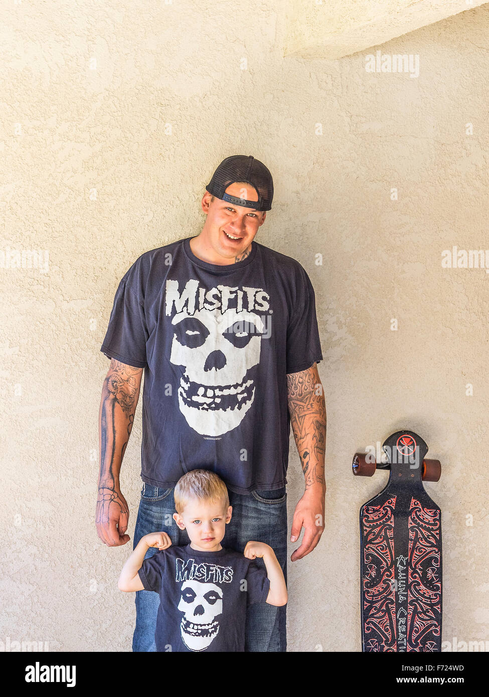 Lo skateboard millenario il padre con i suoi 2 1/2 anno vecchio figlio e  corrispondenza di 'Misfits" t-shirt stand accanto al papà della lunga  skateboard Foto stock - Alamy