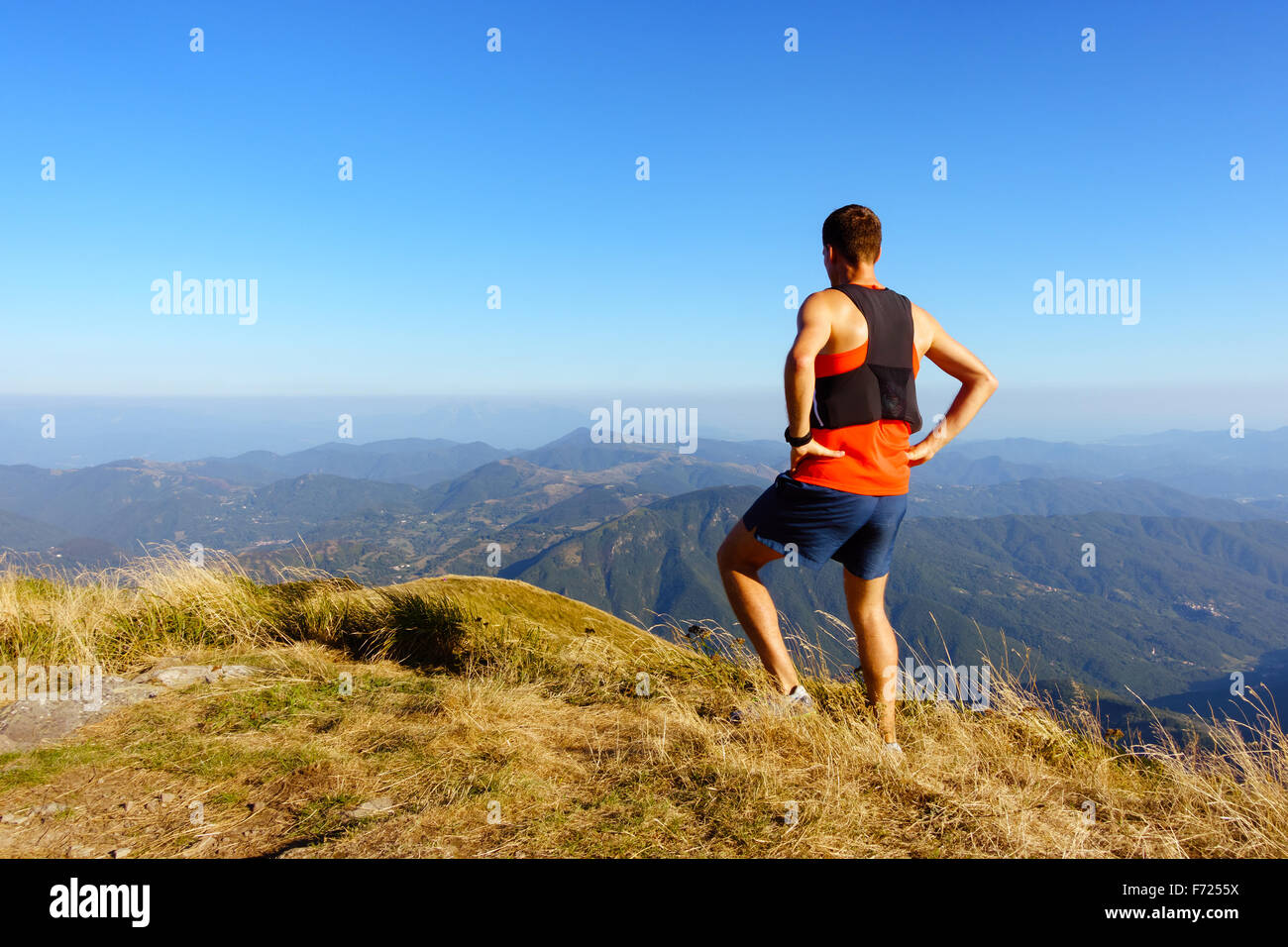 Escursioni a piedi o in esecuzione un uomo guarda ispiranti Montagne Paesaggio. Fitness e uno stile di vita sano all'aperto in estate la natura. Foto Stock