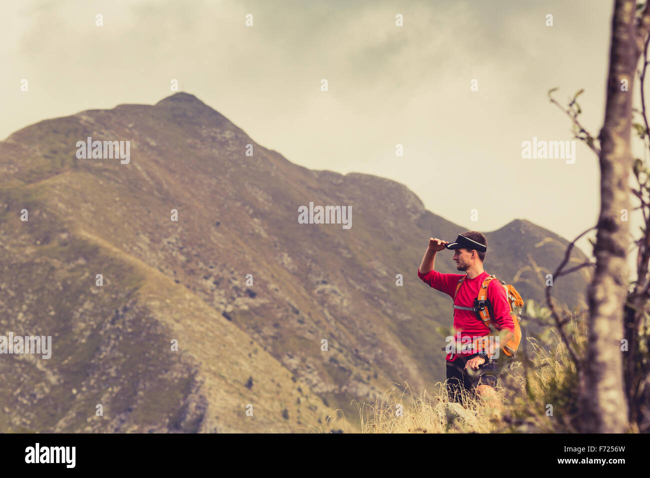 Escursionismo uomo, backpacker, scalatore o trail runner in montagne guardando il bellissimo paesaggio ispiratore vista. Fitness e guarire Foto Stock