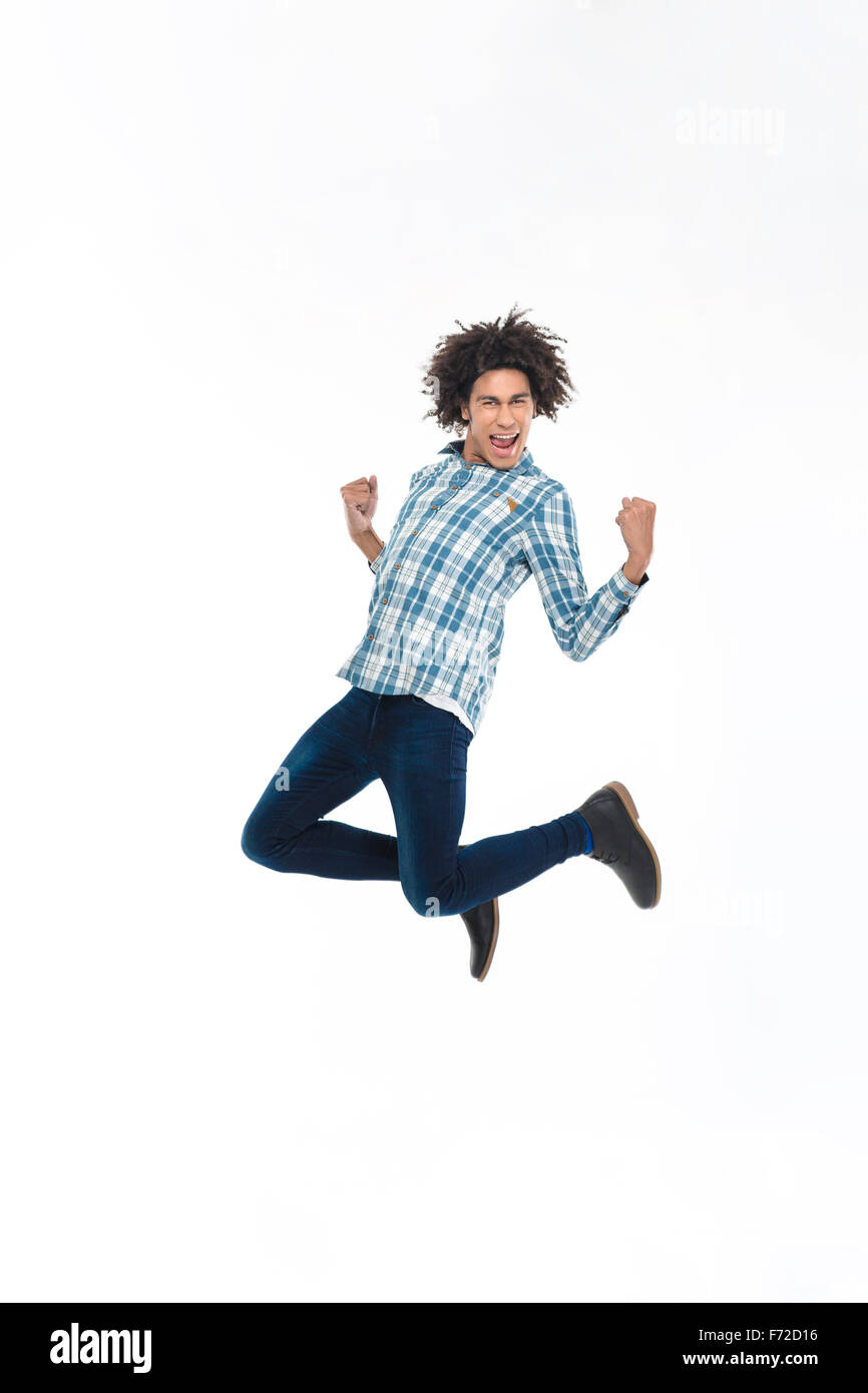 A piena lunghezza Ritratto di un allegro afro-americano jumping isolato su uno sfondo bianco Foto Stock
