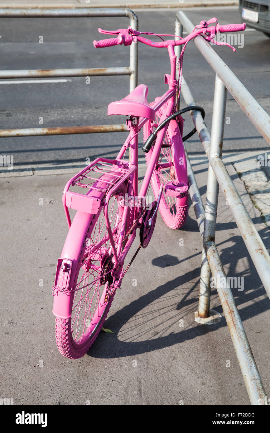 Rosa in stile vecchia bicicletta sorge sul ciglio della strada Foto Stock
