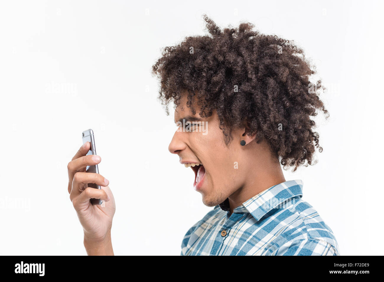 Vista laterale ritratto di afro amerian uomo urlando sullo smartphone isolato su uno sfondo bianco Foto Stock