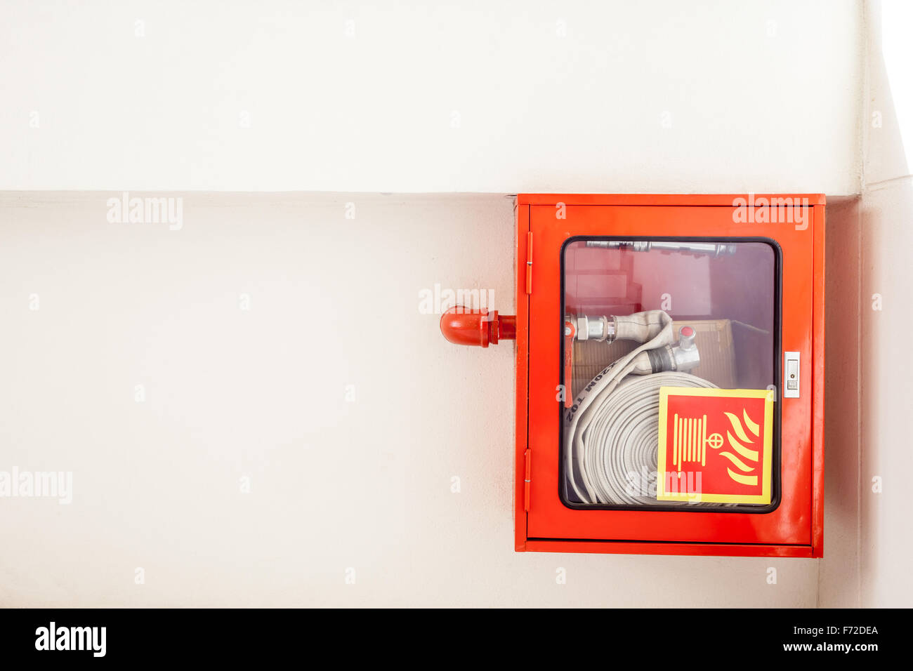 Un tubo antincendio appesi al muro in una scala Foto Stock