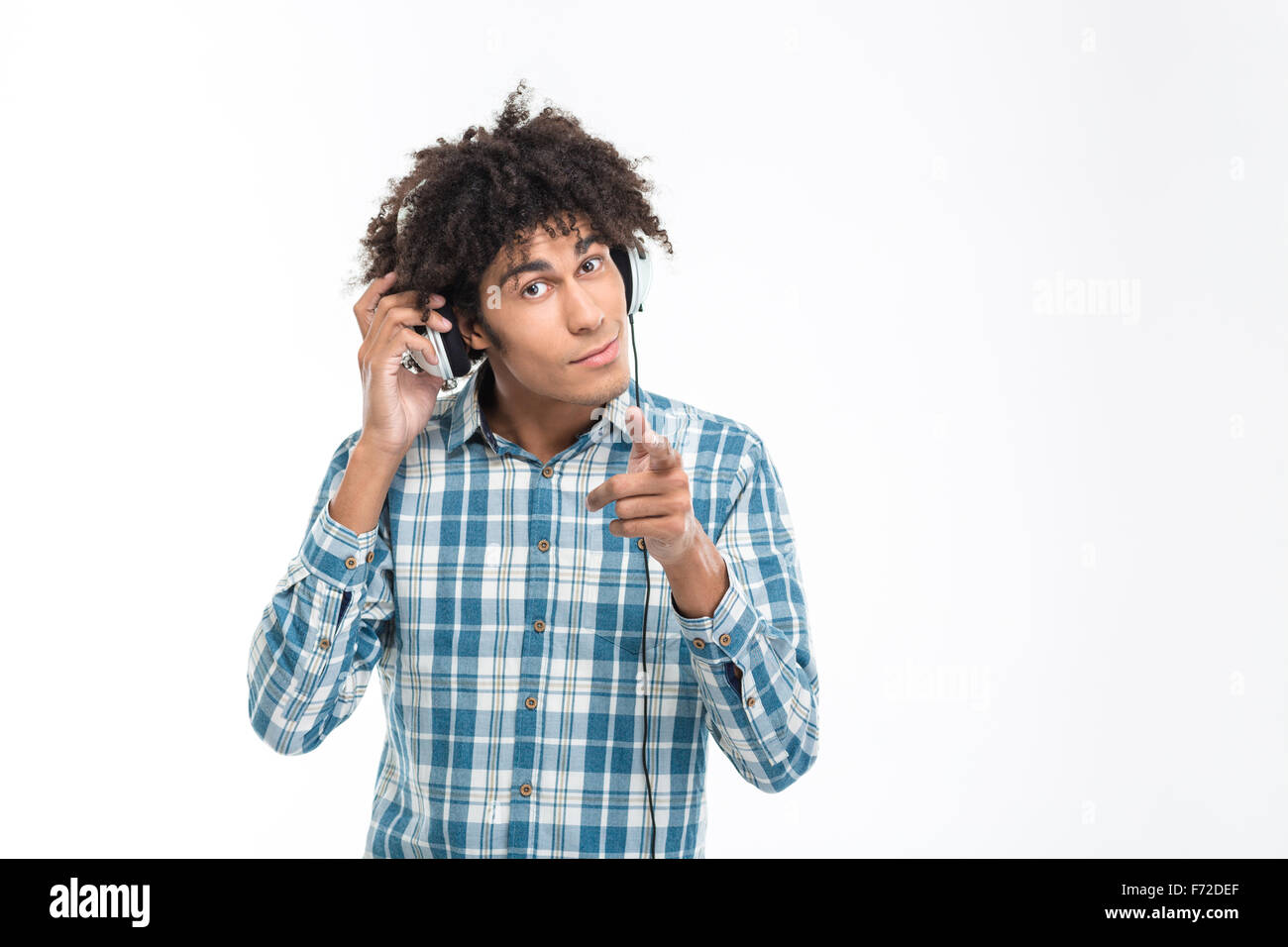 Ritratto di un afro-americano di musica di ascolto in cuffia e pointingfinger in telecamera isolata su uno sfondo bianco Foto Stock