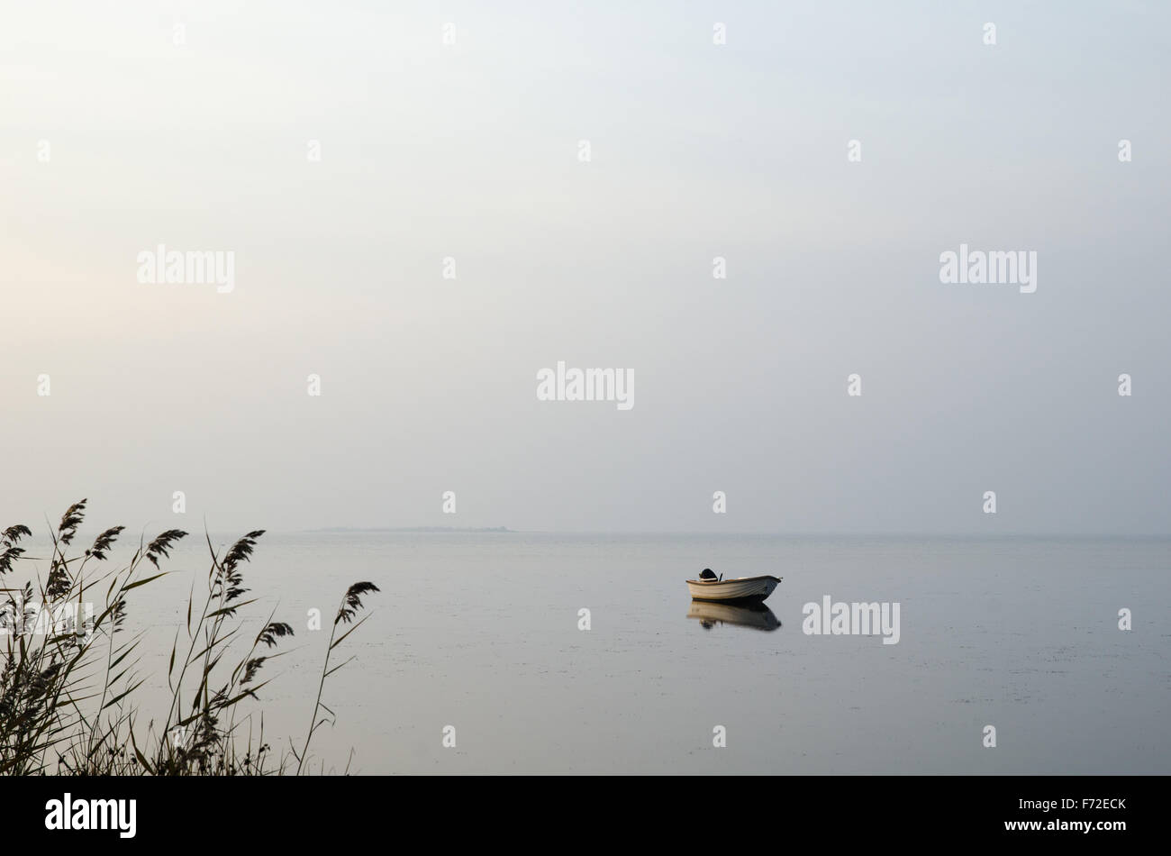 Solo le barche a remi in acqua calma una nebbiosa mattina Foto Stock