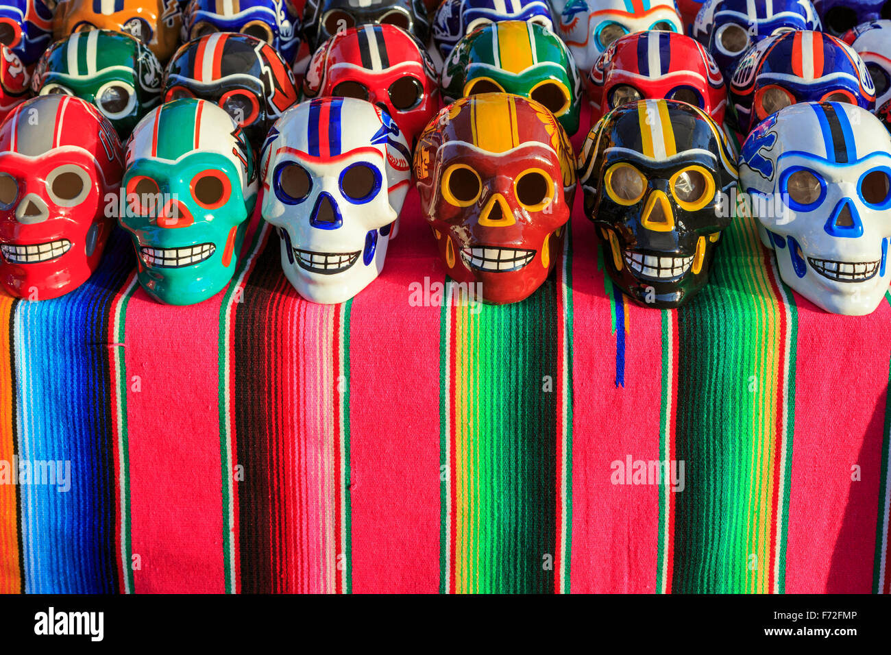 Teschi in porcellana decorata nel football americano colori, stabiliti come parte del Giorno dei Morti, Puerto Vallarta, Messico Foto Stock