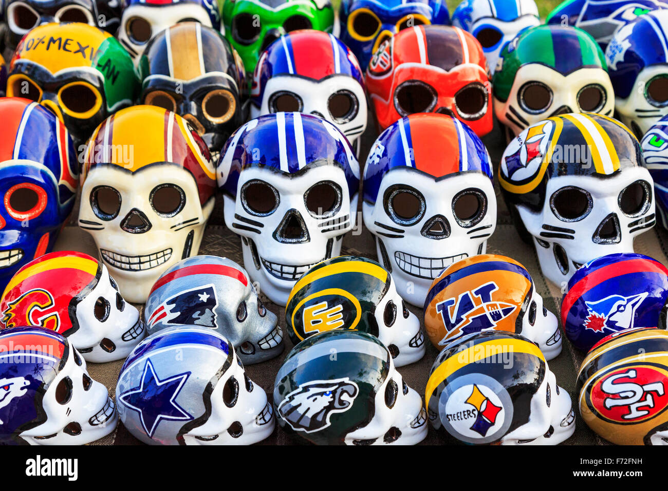 Teschi in porcellana decorata nel football americano colori, stabiliti come parte del Giorno dei Morti, Puerto Vallarta, Messico Foto Stock
