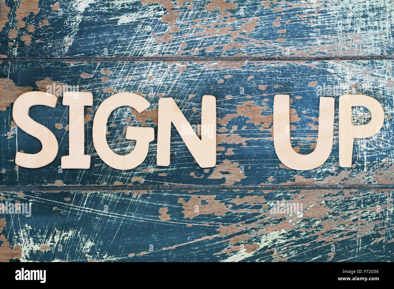 Sign up scritto con lettere in legno sulla superficie rustico Foto Stock