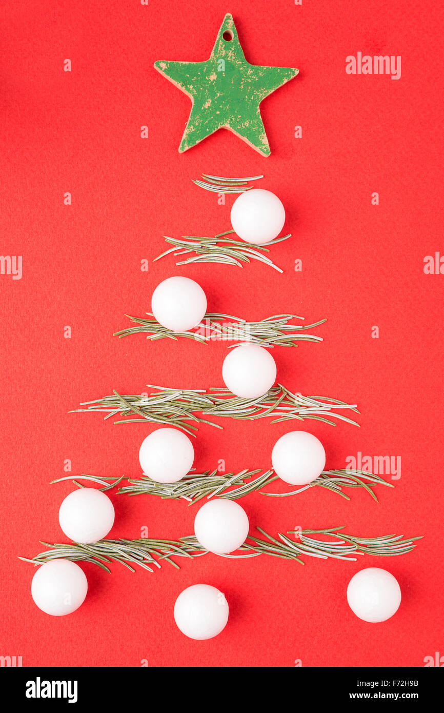Albero di Natale fatto da aghi di abete su sfondo rosso Foto Stock