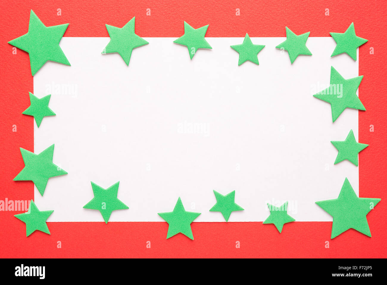 Bianco Natale carta o un invito con le stelle verdi su sfondo rosso Foto Stock