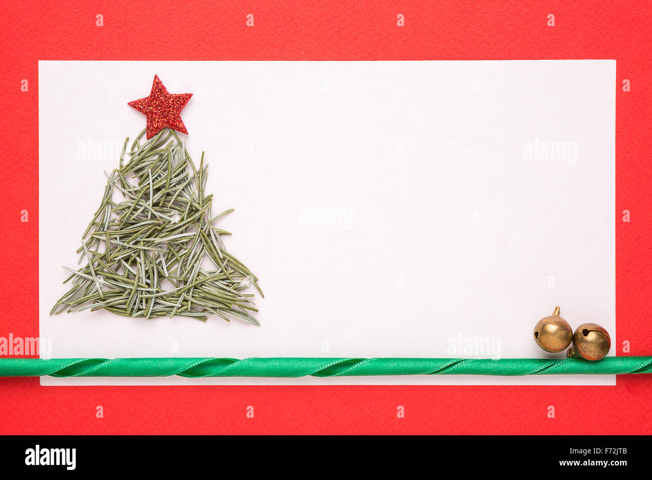 Bianco Natale carta o un invito con albero di Natale fatto da aghi di pino su sfondo rosso Foto Stock
