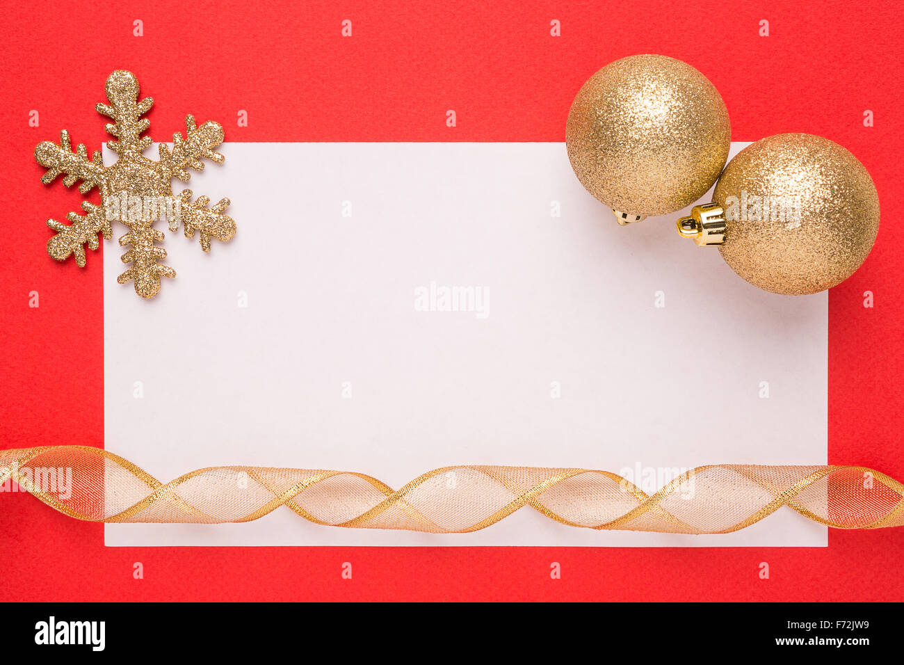 Bianco Natale carta o un invito con il simbolo del fiocco di neve dorata e palle su sfondo rosso Foto Stock