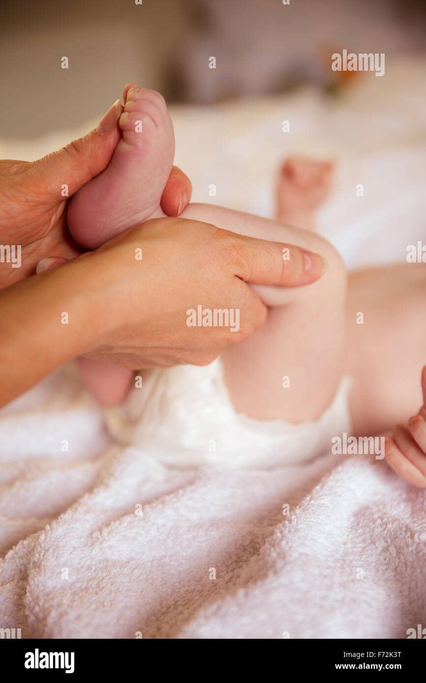 Madre mentre tiene il suo piede di neonati Foto Stock