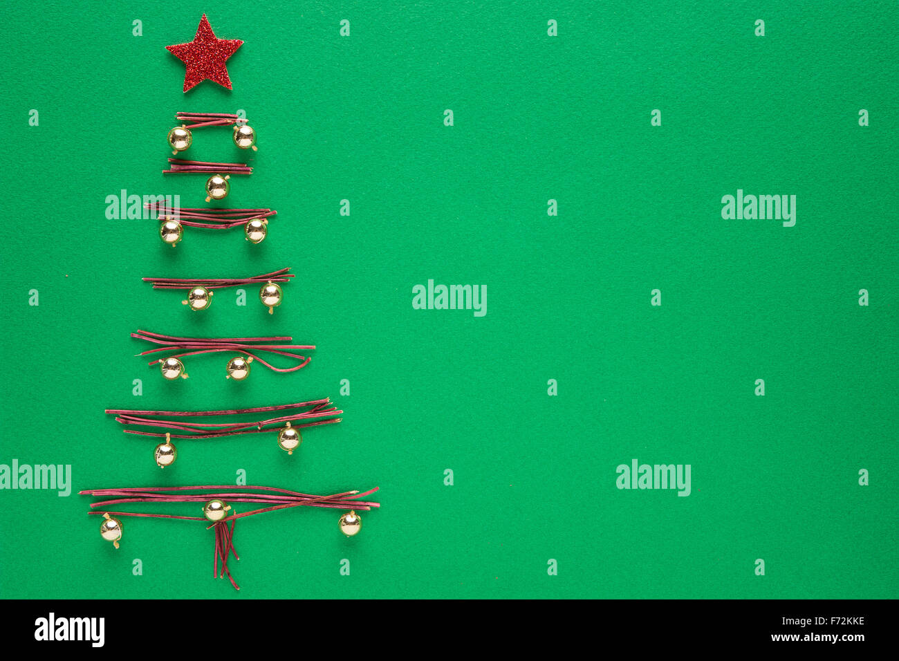 Albero di Natale fatto da rami di legno su sfondo verde Foto Stock