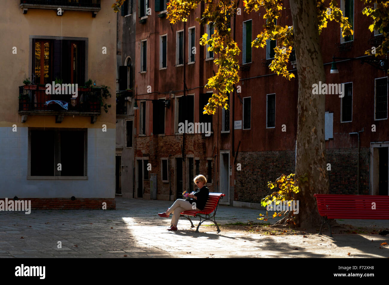 Campo San Agnese nel Sestiere di Dorsoduro a Venezia, Italia. Una donna una donna lettura in autunno. Foto Stock