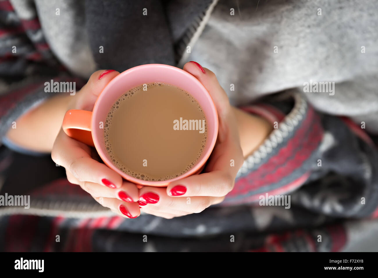Mani femminili tenendo una tazza di bevanda calda Foto Stock