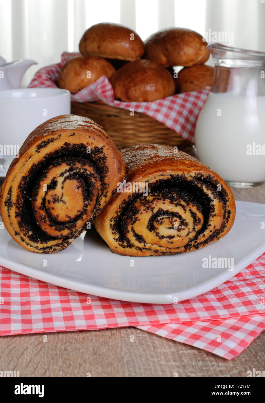 Panini appena sfornati con semi di papavero su una piastra di tovaglioli Foto Stock