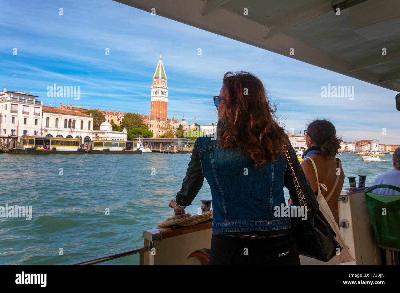 Un elegante donna guarda fuori da un vaporetto sul Canal Grande a Venezia, Italia Foto Stock