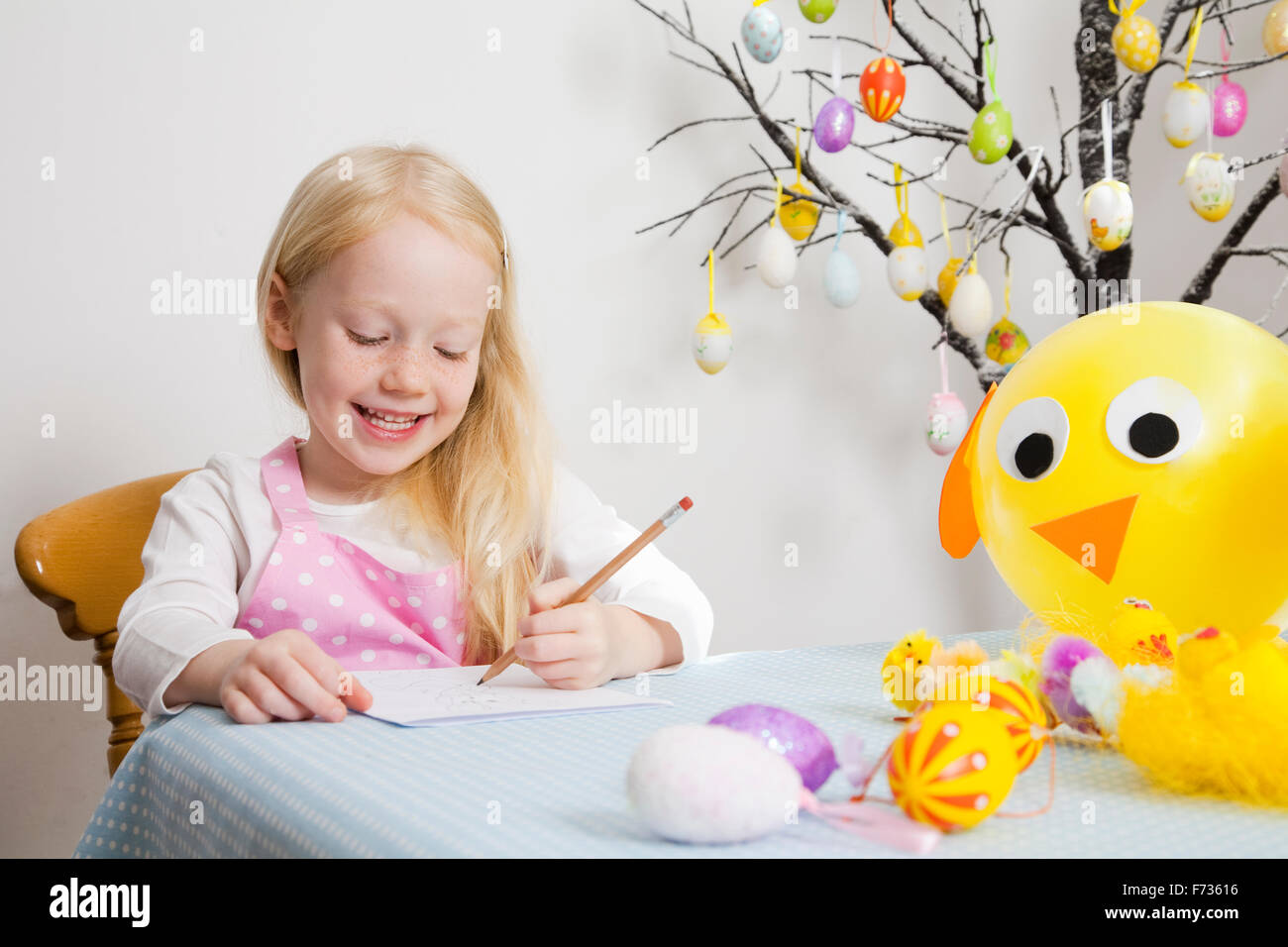 Una ragazza seduta al tavolo di disegno. Foto Stock